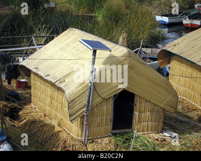 Pannelli fotovoltaici attaccato a un reed casa in isole galleggianti - Islas de los Uros - nel Lago Titicaca, Perù. Foto Stock