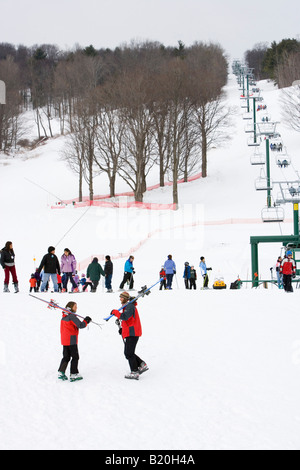 Un uomo e una donna a capo di piste a Quechee Ski Hill in Quechee, Vermont. Foto Stock