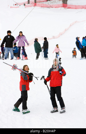 Un uomo e una donna a capo di piste a Quechee Ski Hill in Quechee, Vermont. Foto Stock