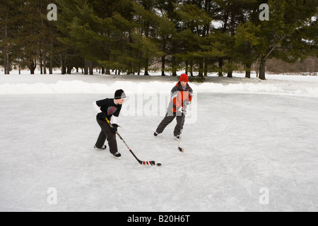 Ragazzi giocare ad hockey su un laghetto congelato in Quechee, Vermont. Foto Stock