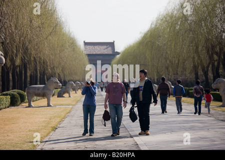I turisti occidentali con guida cinese a piedi lungo lo spirito modo presso le Tombe dei Ming sito cinese di Pechino Foto Stock