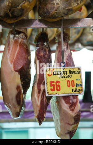 Spagna Madrid suini gambe appesi in museo de jamon store Iberico sul segno in spagnolo e il prezzo in euro Foto Stock