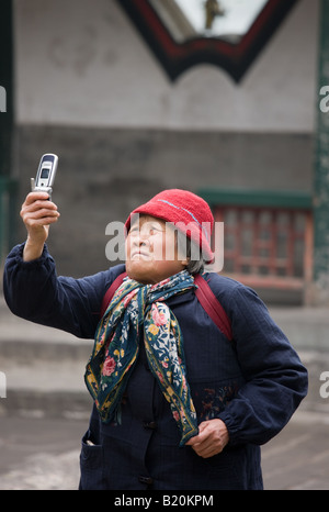 La donna prende una fotografia con un telefono cellulare presso il Palazzo Estivo Pechino CINA Foto Stock
