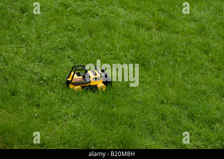 Un giocattolo Tonka bulldozer seduto in erba come se pronto a cancellare la terra Foto Stock