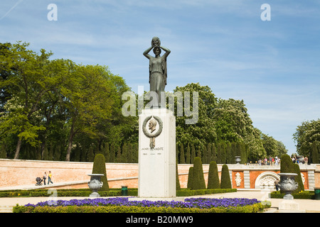 Spagna Madrid le persone camminare sul marciapiede attraverso giardini nel Parco del Retiro Parque del Buen Retiro scolpito di cespugli e fiori Foto Stock
