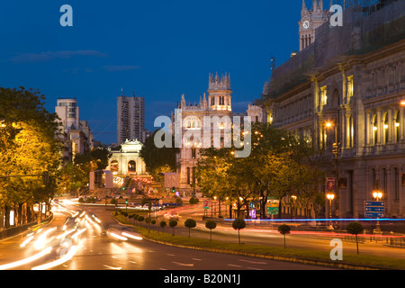 Spagna Madrid di sfocatura di veicoli che si muovono su Gran Via al tramonto la chiesa e gli edifici governativi lungo la strada Foto Stock