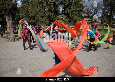 Donne praticare il tai chi ballare con nastri nel parco del Tempio del cielo di Pechino CINA Foto Stock