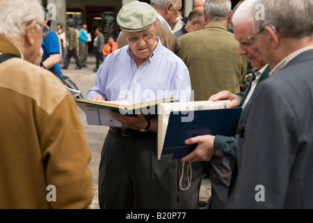 Spagna Madrid collettori del bollo commercio e vendere le collezioni in Plaza Mayor di domenica mattina gli uomini vista notebook dei timbri Foto Stock