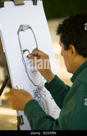 Spagna Madrid Man disegna la caricatura faccia con carboncino su cavalletto nel Parco del Retiro Parque del Buen Retiro Foto Stock