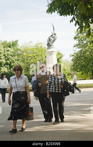 Spagna Madrid Spagnolo adulti camminare sul marciapiede attraverso giardini nel Parco del Retiro Parque del Buen Retiro vicino alla fontana Foto Stock
