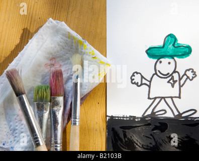 Pennelli bagnati e un bambino s pittura ad acquarello di uno sceriffo concentrarsi sulle spazzole Foto Stock