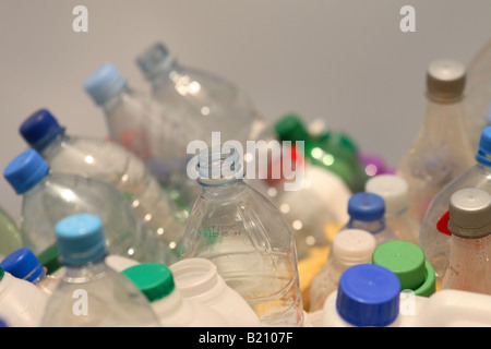 Pila pila assortiti di bottiglie di plastica con coperchi colorati al centro di raccolta rifiuti Foto Stock