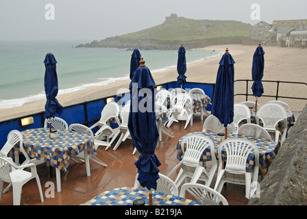 Un vuoto cafe' affacciato sulla spiaggia porthmeor,st.ives,cornwall,uk,su un giorno di gran pioggia Foto Stock