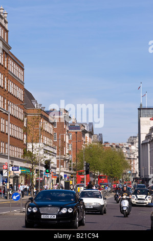 Il traffico e l'architettura lungo Kensington High Street Kensington W8 London Regno Unito Foto Stock