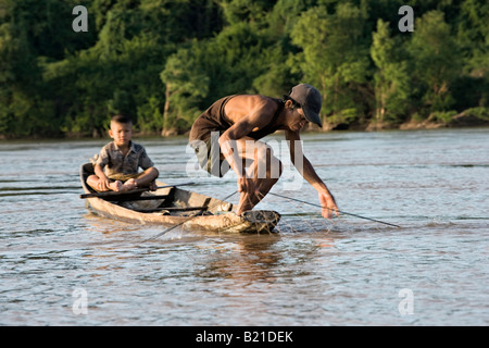 Fisherman e figlio di controllare le loro Tutina in rete, del fiume Mekong, sud Laos Foto Stock