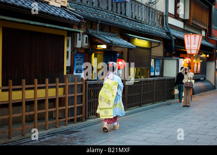 Una Geisha camminando attraverso le strade di Gion a Kyoto in Giappone Foto Stock