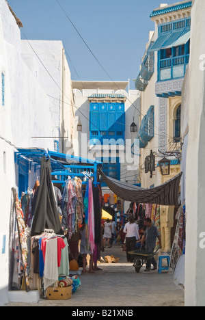 Vista verticale di un tipico streetscene con edifici bianchi e vicoli stretti all'interno della vecchia Medina a Hammamet in una giornata di sole Foto Stock