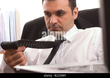 Imprenditore guardando la sua cravatta. Foto Stock