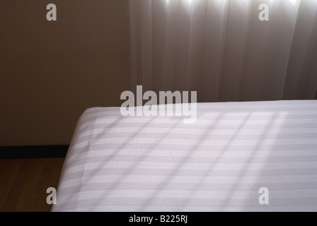 Ordinato e pulito il letto con lenzuola bianche dal moderno appartamento in paese del terzo mondo Foto Stock