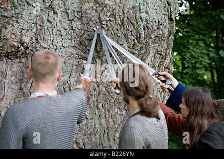 Soldati medievali attraversando spade intorno all antica quercia Foto Stock