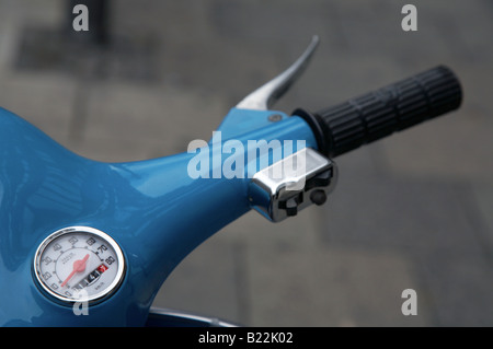 Manubrio Tachimetro e contachilometri di un blu brillante in vecchio stile retrò scooter parcheggiato su un marciapiede in una città europea Foto Stock