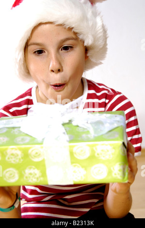 Close-up della ragazza con un regalo di natale e guardando sorpreso Foto Stock