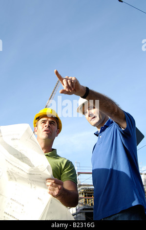 Basso angolo vista di due architetti maschio al sito in costruzione Foto Stock