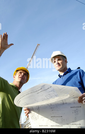 Basso angolo vista di due architetti maschio al sito in costruzione Foto Stock