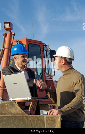 Due architetti maschio stringe la mano al sito in costruzione Foto Stock