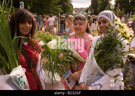 Donne asiatiche con i loro acquisti floreali a Hampton Court Flower Show, UK. Domenica 13 Luglio 2008 Foto Stock