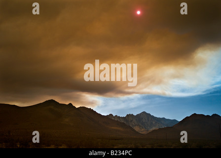 CALIFORNIA Lone Pine il sole fa capolino tra le nuvole di fumo pesante da incendi boschivi bruciare nelle montagne della Sierra Nevada Foto Stock