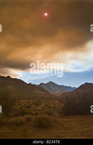 CALIFORNIA Lone Pine il sole fa capolino tra le nuvole di fumo pesante da incendi boschivi bruciare nelle montagne della Sierra Nevada Foto Stock
