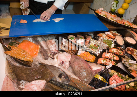 Dettaglio da un contatore al mercato del pesce di Göteborg Svezia pescivendolo organizza vari pesci e filetti di pesce Foto Stock