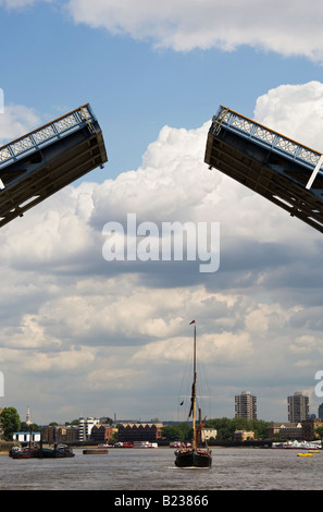 Barche che attraversa la torre basculante Ponte sul Fiume Tamigi a Londra Foto Stock