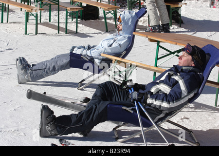 Una giovane donna si appoggia su una sedia al di fuori di un moderno ristorante a Bansko, montagne Pirin, Bulgaria. Foto Stock