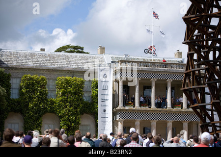 Stunt rider, Dougie Lampkin, sul tetto della casa di Goodwood con la folla a guardare Foto Stock