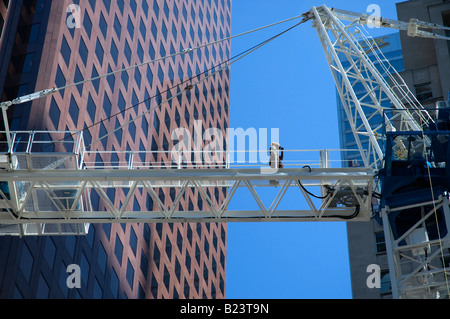 Lavoratore passeggiate attraverso gru a torre sul sito in costruzione. Foto Stock