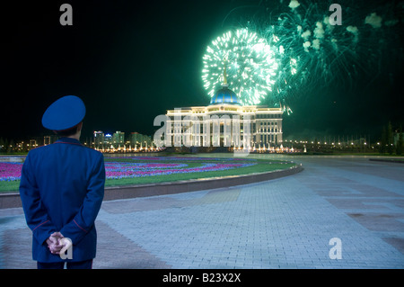 Un poliziotto guardando fuochi d'artificio su Ak Orda residenza del Presidente della Repubblica del Kazakistan a Astana, Kazakistan Foto Stock