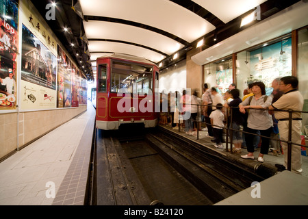 I passeggeri di salire a bordo del Victoria Peak Tram in corrispondenza del suo terminale inferiore dalla stazione di Hong Kong, Cina SAR. Foto Stock