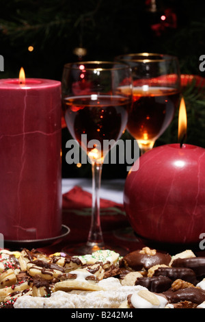 Biscotti di Natale su un piatto e due bicchieri di vino con due candele accese sfocate sullo sfondo biscotti dolci senza vista ad alta risoluzione Foto Stock