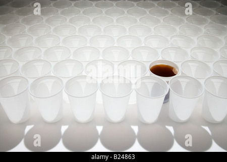 Tazza di cola tra i bicchieri vuoti Foto Stock