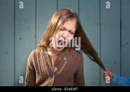 Ragazza dopo aver tirato i capelli Foto Stock