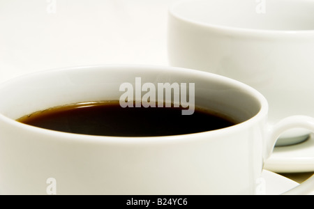 Due tazze di caffè uno pieno di caffè nero Foto Stock