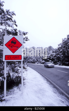 "Attenzione di ghiaccio' roadsignwith sullo sfondo di montagne coperte di neve lungo la scenic Milford Road (autostrada statale 94), Fiordland, NZ Foto Stock