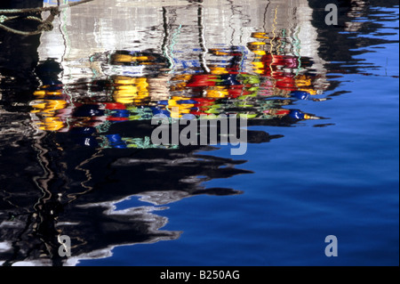 Abstract riflessioni di una barca da pesca con colorati boe, Milford Sound, Fiordland, Nuova Zelanda Foto Stock