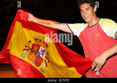 L'uomo celebrando la Spagna football team vittoria sulla Germania In UEFA EURO 2008 sventola una bandiera spagnola come se fosse un toreador Foto Stock