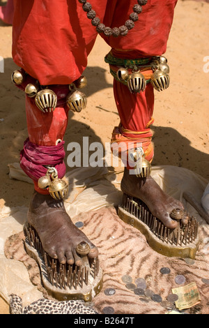 Un sadhu sorge sotto un ombrello mentre in piedi sulle scarpe di chiodi a Talakkad in Karnataka. Foto Stock