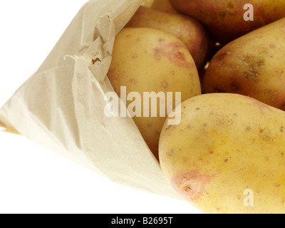 Carta marrone borsa di bianco fresco intero patate cotte con nessun popolo copia di spazio e di un tracciato di ritaglio pronti per la pelatura e cottura Foto Stock