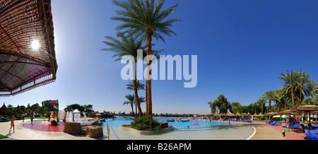 Panorama dell'area piscina con palme e la vista del Nilo e la riva occidentale del Nilo, Coccodrillo Isola, Luxor, Egitto, Af Foto Stock