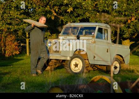 Workman il caricamento di una trave di legno in una storica 1963 Landrover serie 2a truckcab in originale e in piena condizione di lavoro. Foto Stock